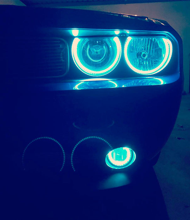 Close-up of cyan LED headlight and fog light halo rings installed on a Dodge Challenger.