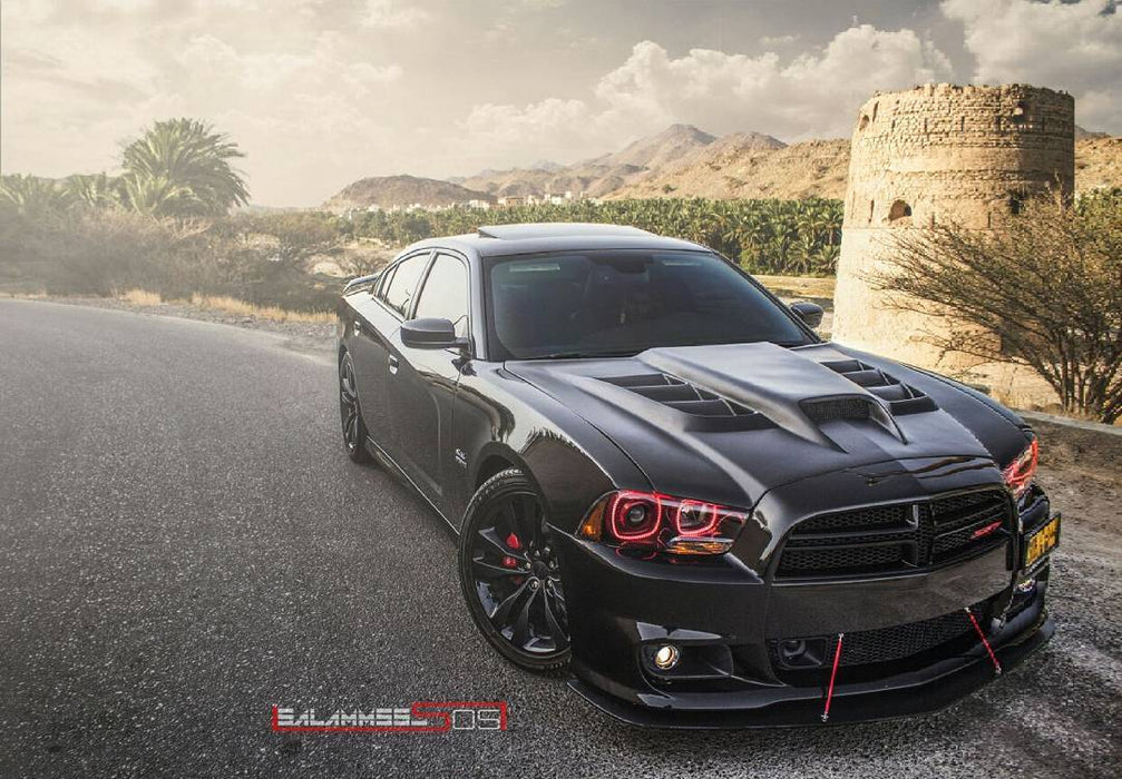 Three quarters view of a black Dodge Charger with red LED headlight halo rings installed.