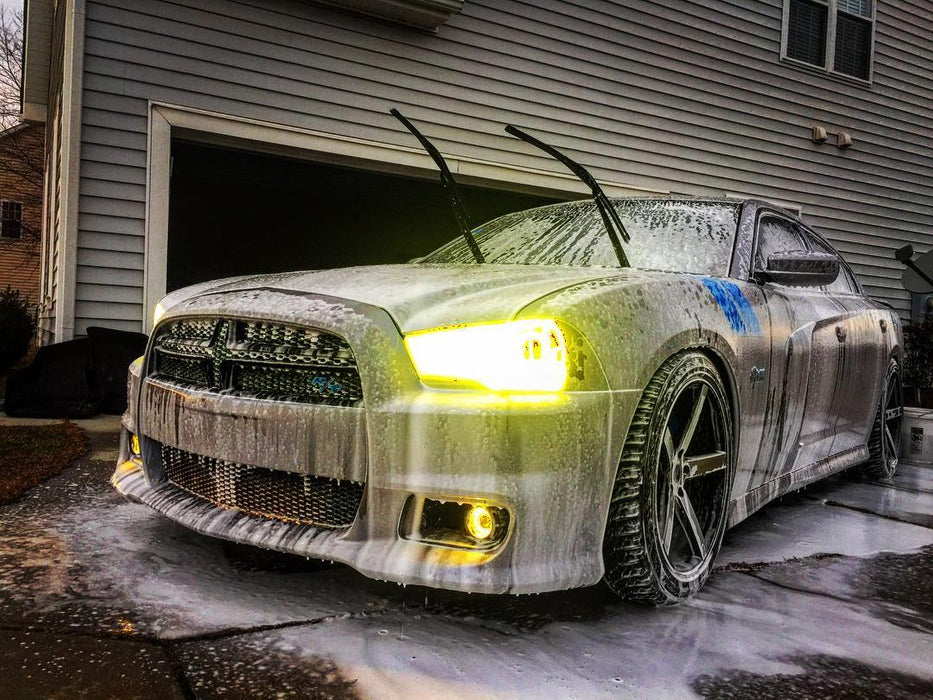 Three quarters view of a Dodge Charger with yellow LED headlight and fog light halo rings installed.