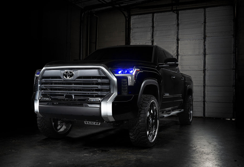 Three quarters view of a black Toyota Tundra with blue demon eye projectors.
