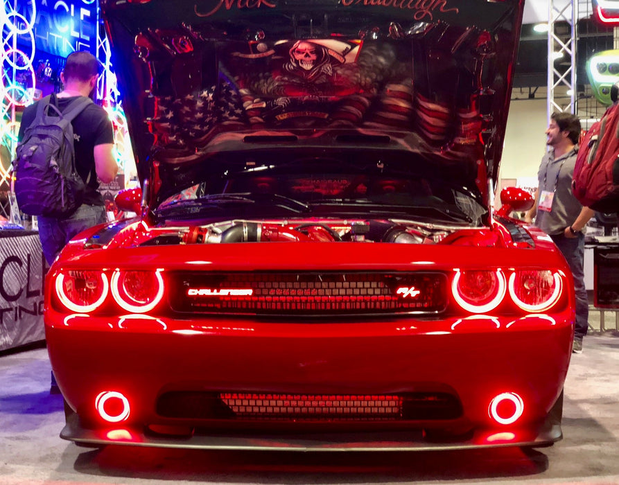 Front end of a Dodge Challenger with red LED headlight and fog light halo rings.