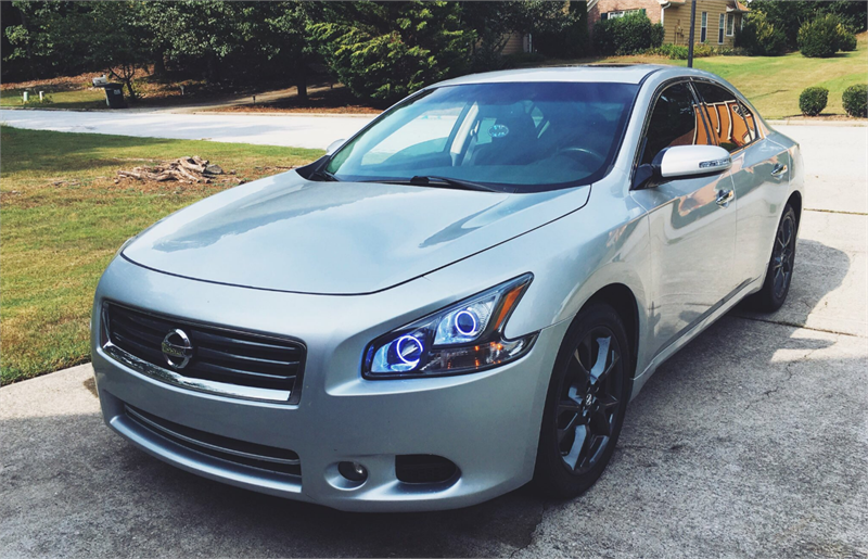 Three quarters view of a Nissan Maxima with white LED headlight halo rings.