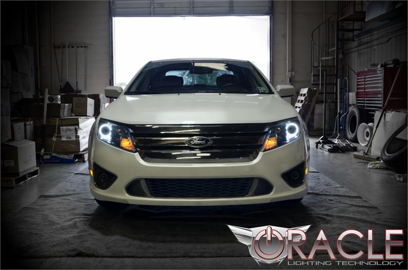 Front end of a Ford Fusion with white LED headlight halo rings installed.