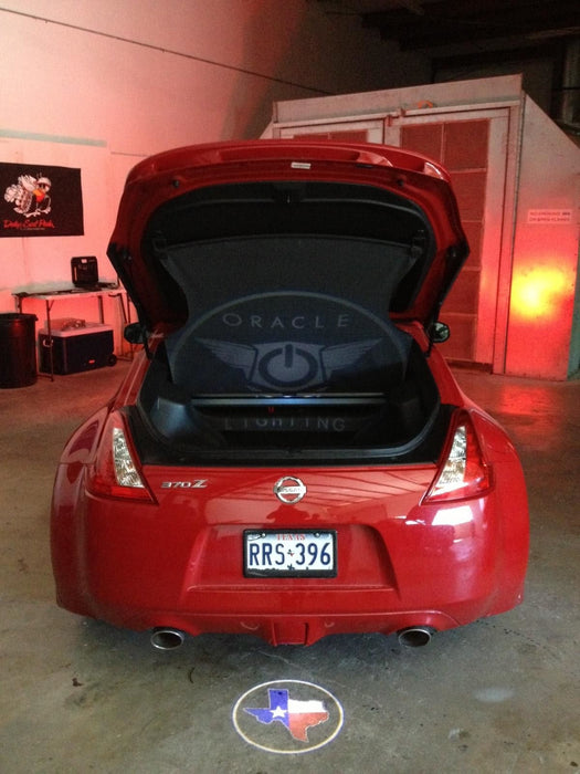 Rear end of a Nissan 370Z with GOBO Projectors installed, showing the Texas flag.