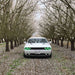 Front view of a white Dodge Challenger with green LED headlight and fog light halo rings installed.