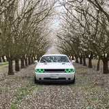 Front view of a white Dodge Challenger with green LED headlight and fog light halo rings installed.