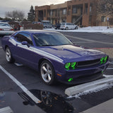 Three quarters view of a purple Dodge Challenger, with green LED headlight and fog light halo rings installed.