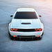 Front view of a white Dodge Challenger with red LED headlight and fog light halo rings installed.