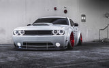 Three quarters view of a white Dodge Challenger with white LED headlight and fog light halo rings installed.