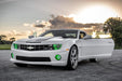 Three quarters view of a Chevrolet Camaro with green LED headlight and fog light halo rings installed.