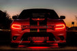 Front end of a red Dodge Charger with red headlight DRLs.