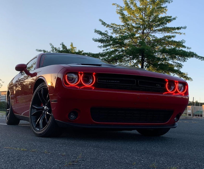 Three quarters view of a red Dodge Challenger with red LED headlight halo rings installed.