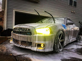 Three quarters view of a Dodge Charger with yellow LED headlight and fog light halo rings installed.