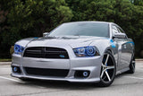 Three quarters view of a silver Dodge Charger with blue LED headlight halo rings installed.