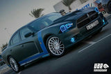 Three quarters view of a black Dodge Charger with cyan LED halo rings installed.