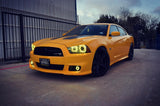 Three quarters view of a yellow Dodge Charger with yellow LED headlight and fog light halo rings installed.