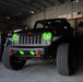 Front end of a Jeep Wrangler JK with green LED headlight and fog light halos installed.