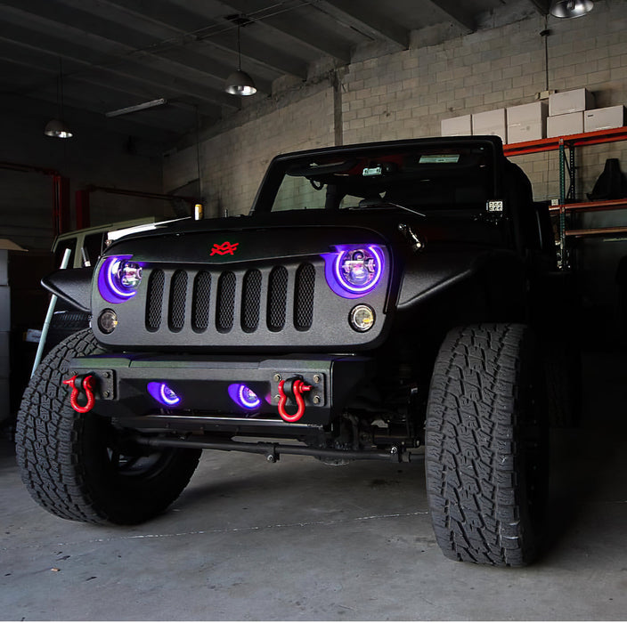 Front end of a Jeep Wrangler JK with purple LED headlight and fog light halos installed.