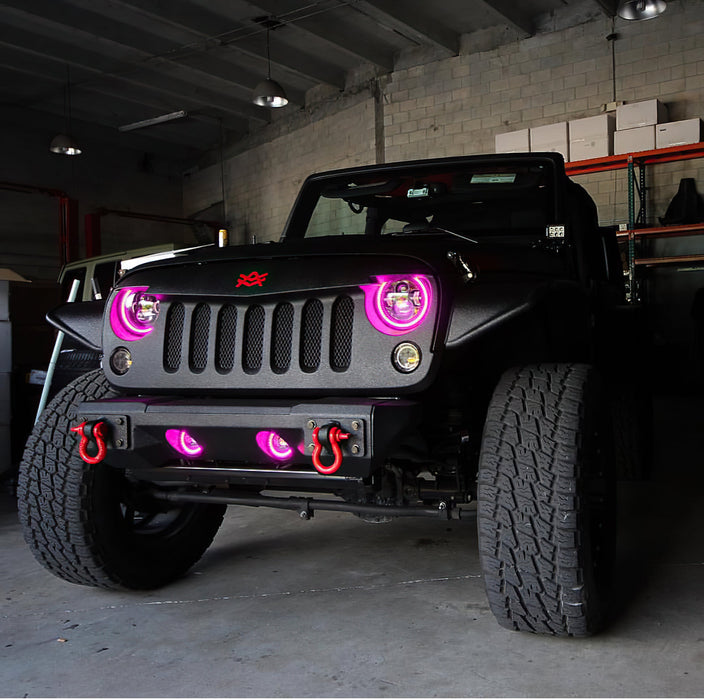 Front end of a Jeep Wrangler JK with pink LED headlight and fog light halos installed.