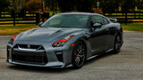 Three quarters view of a silver Nissan GT-R with red headlight DRLs.