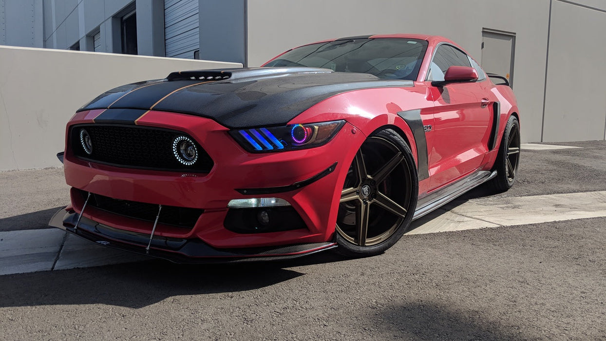 Three quarters view of a red Ford Mustang with rainbow headlight halos and DRLs.