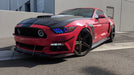 Three quarters view of a red Ford Mustang with rainbow headlight halos and DRLs.