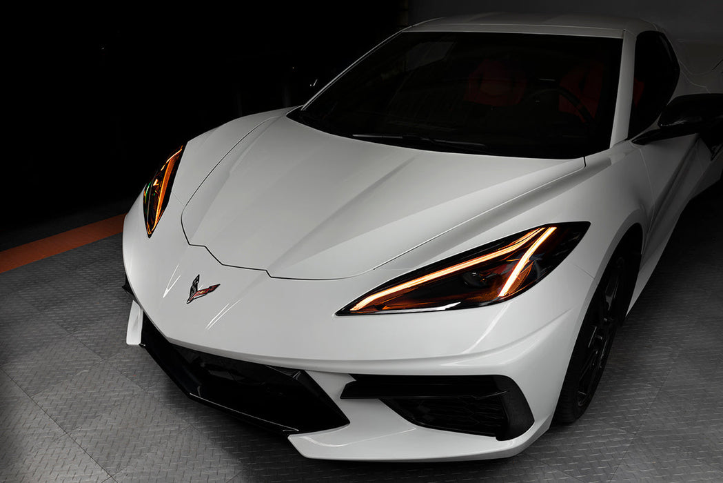 Front end of a white C8 Corvette with amber headlight DRLs.