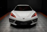 Front view of a white C8 Corvette with red headlight DRLs.