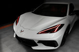 Front end of a white C8 Corvette with red headlight DRLs.