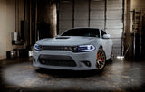 Three quarters view of a grey Dodge Charger with white headlight DRLs.