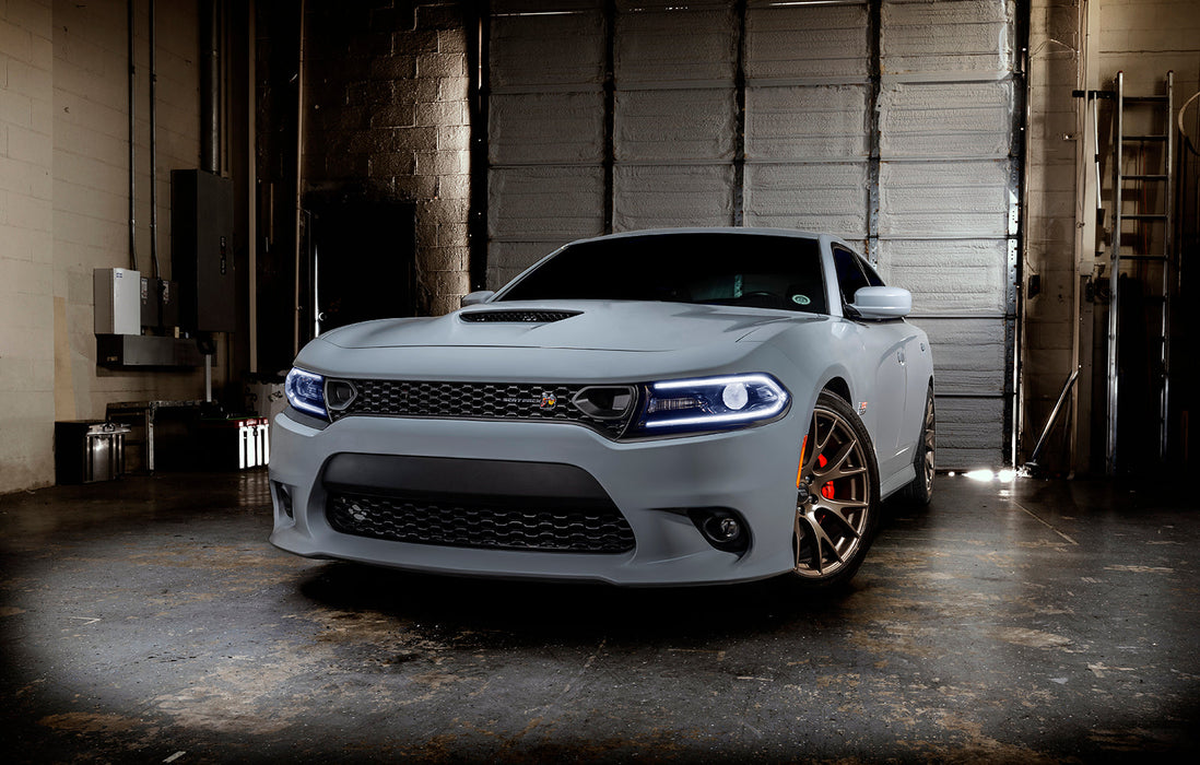 Three quarters view of a grey Dodge Charger with white headlight DRLs.