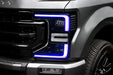 Close-up of a Ford Superduty headlight with purple DRLs.