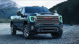 Three quarters view of a GMC Sierra with green headlight DRLs.