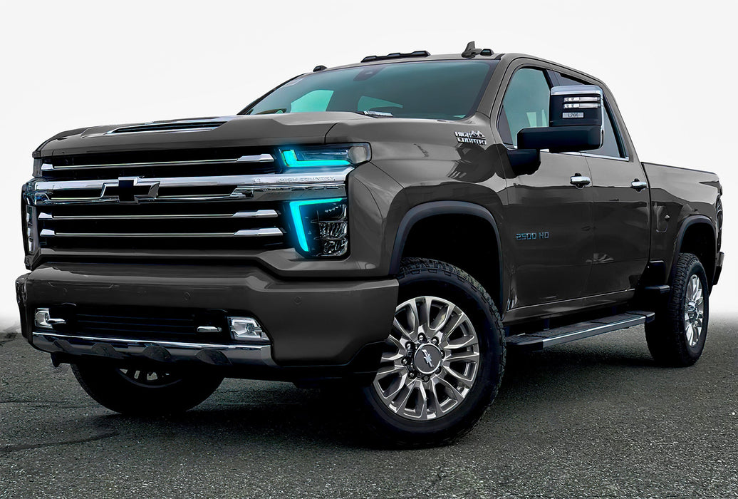 Three quarters view of a Chevy Silverado with cyan headlight DRLs.