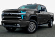 Three quarters view of a Chevy Silverado with cyan headlight DRLs.