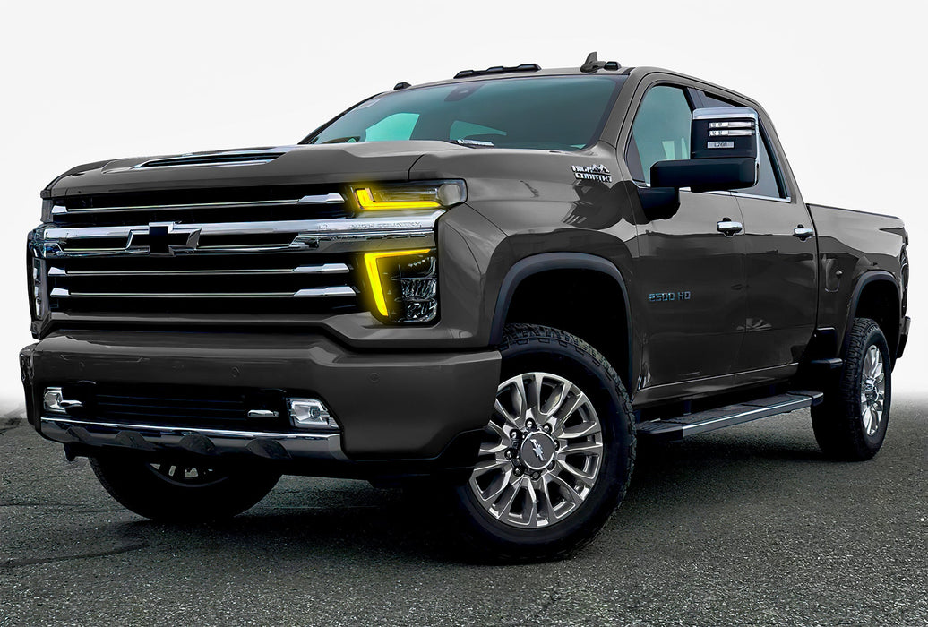 Three quarters view of a Chevy Silverado with yellow headlight DRLs.