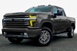 Three quarters view of a Chevy Silverado with yellow headlight DRLs.