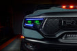 Close-up of Ram 1500 headlights with blue DRLs and green demon eye projectors.