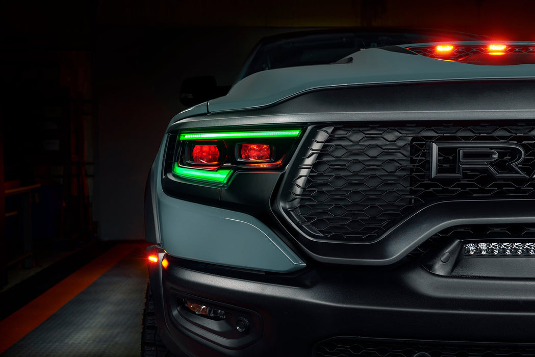 Close-up of Ram 1500 headlights with green DRLs and red demon eye projectors.