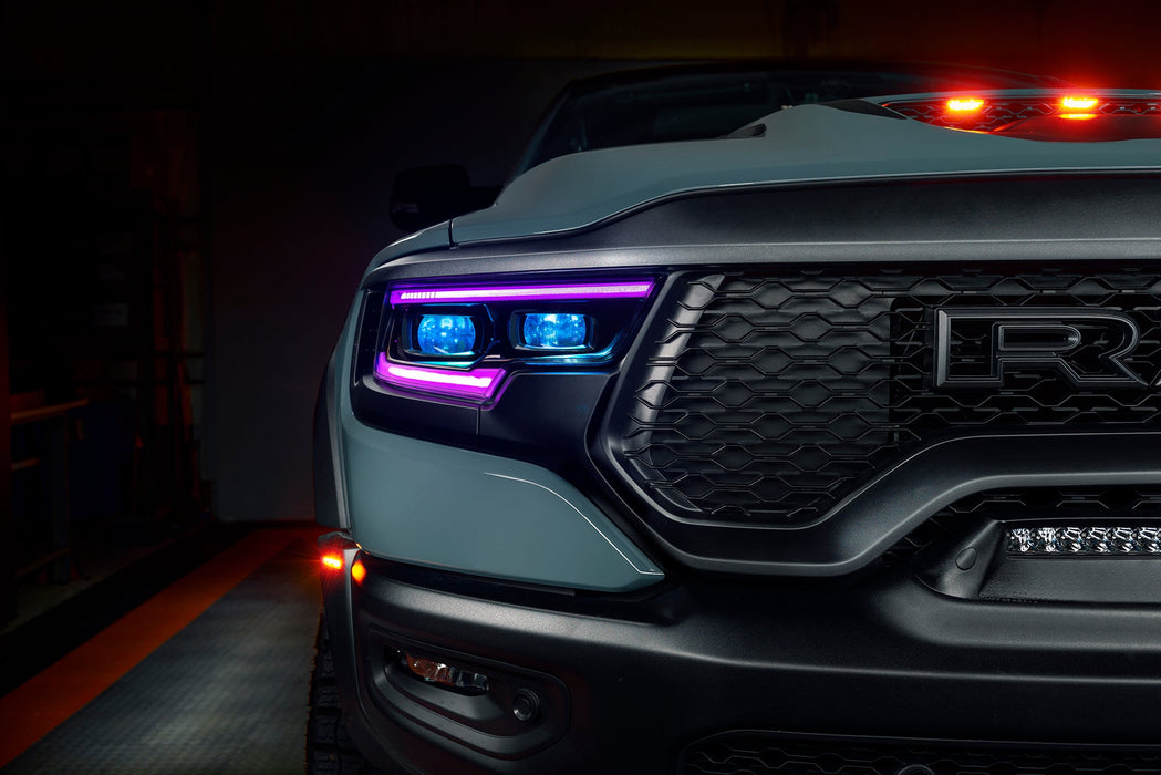 Close-up of Ram 1500 headlights with purple DRLs and cyan demon eye projectors.