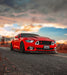 Three quarters view of a Ford Mustang with white LED headlight halos and DRLs.