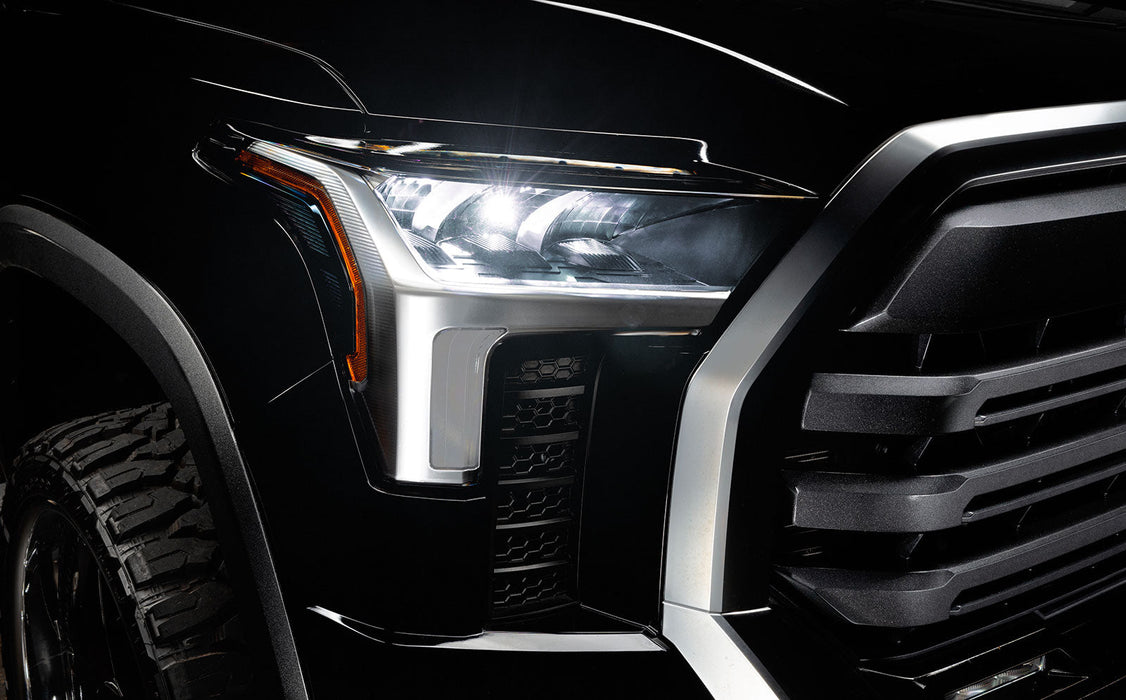 Close-up of a 2022+ Toyota Tundra headlight module installed with white demon eye projector.