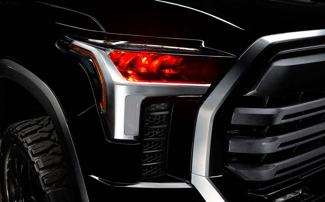 Close-up of a 2022+ Toyota Tundra headlight module installed with red demon eye projector.