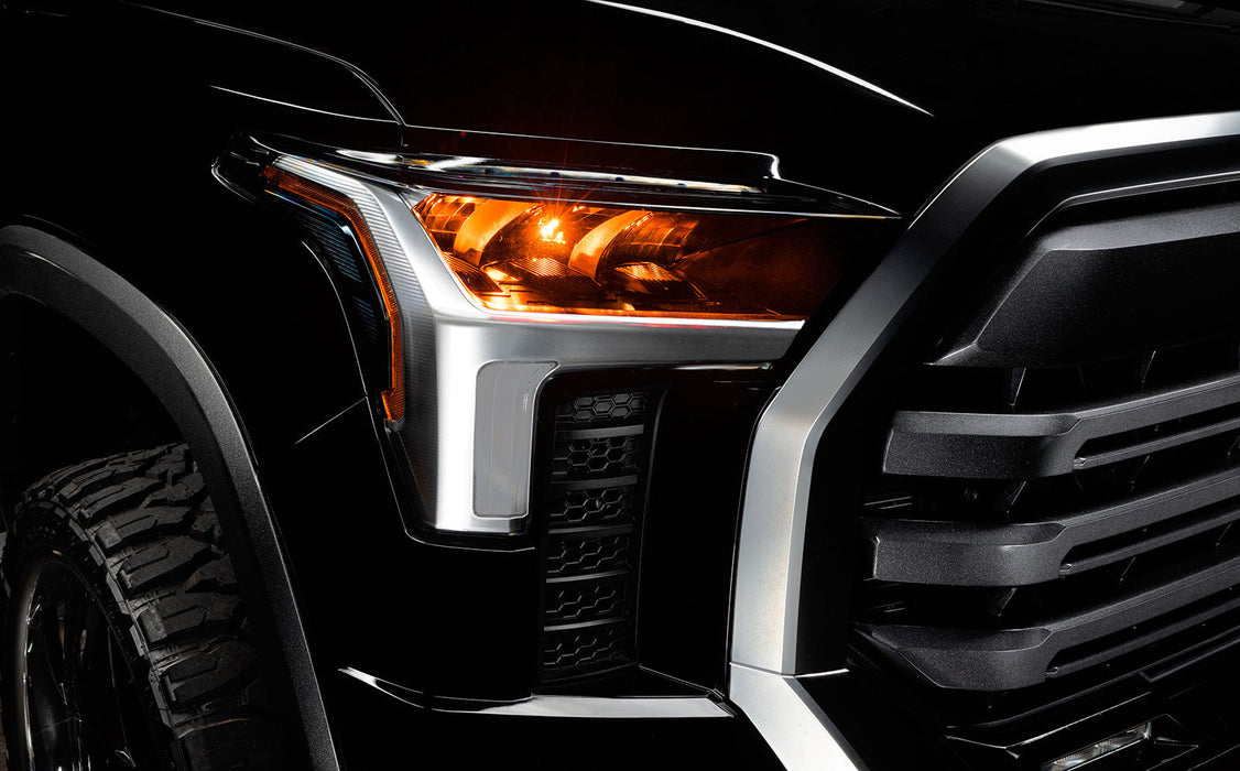 Close-up of a 2022+ Toyota Tundra headlight module installed with amber demon eye projector.