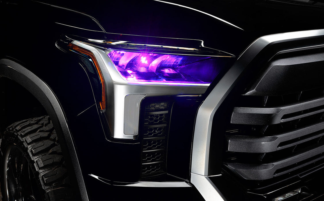 Close-up of a 2022+ Toyota Tundra headlight module installed with pink demon eye projector.