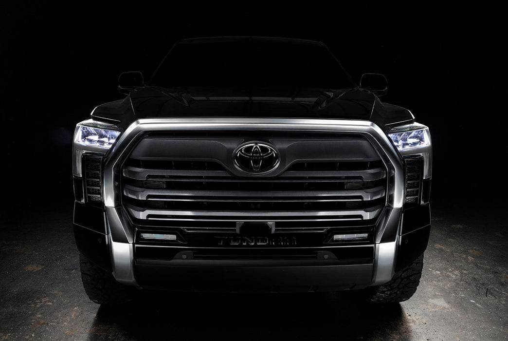 Straight front view of a black Toyota Tundra with white demon eye projectors.