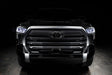 Straight front view of a black Toyota Tundra with white demon eye projectors.
