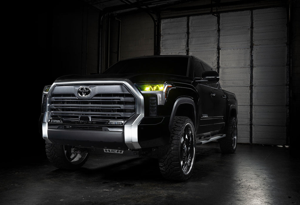 Three quarters view of a black Toyota Tundra with yellow demon eye projectors.