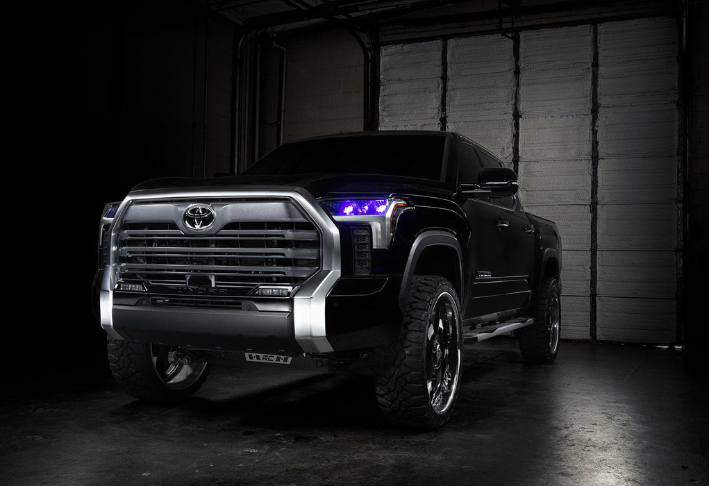 Three quarters view of a black Toyota Tundra with purple demon eye projectors.