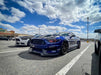 Three quarters view of a Ford Mustang with red headlight halos and DRLs.